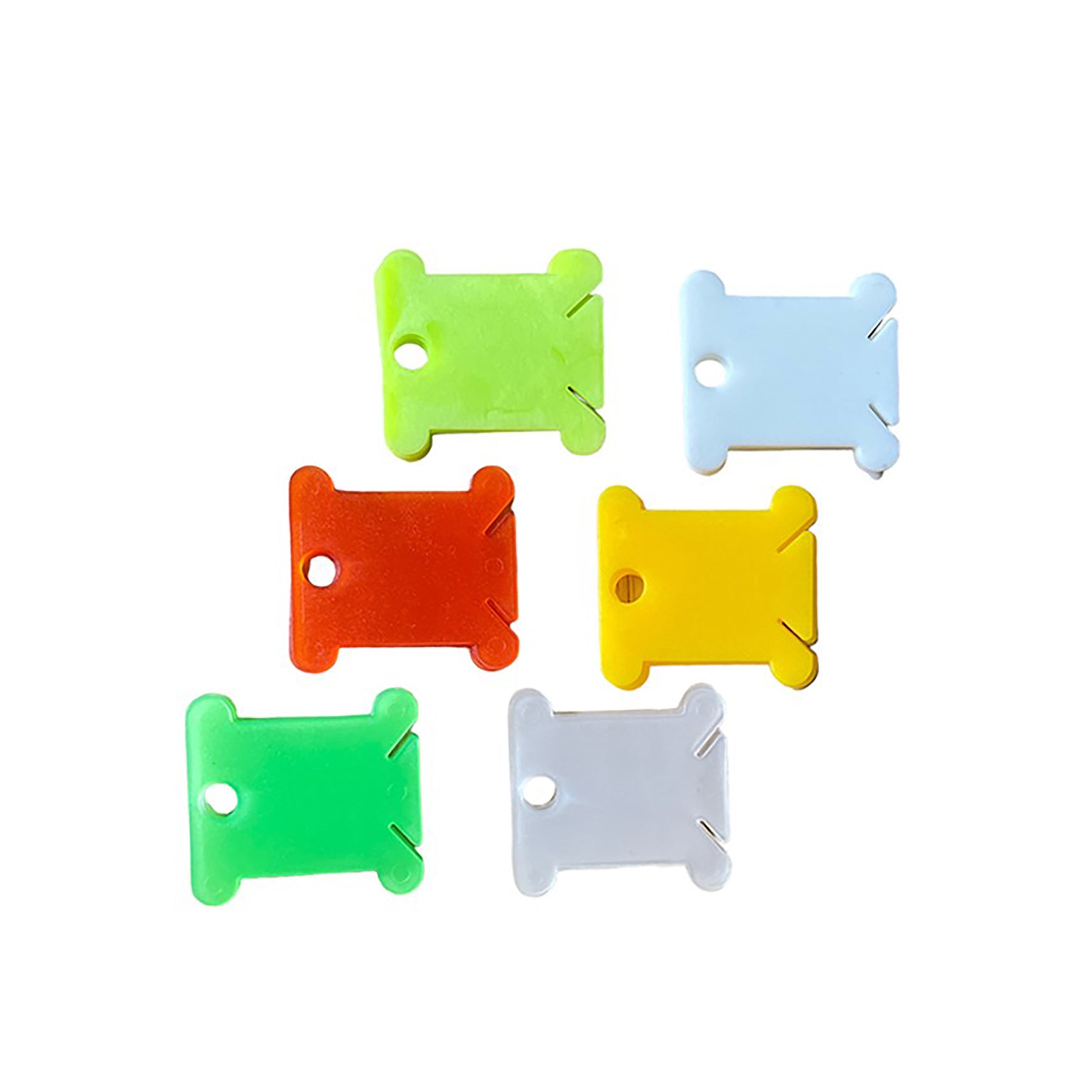 Colorful plastic embroidery floss bobbins in green, yellow, red, and white.